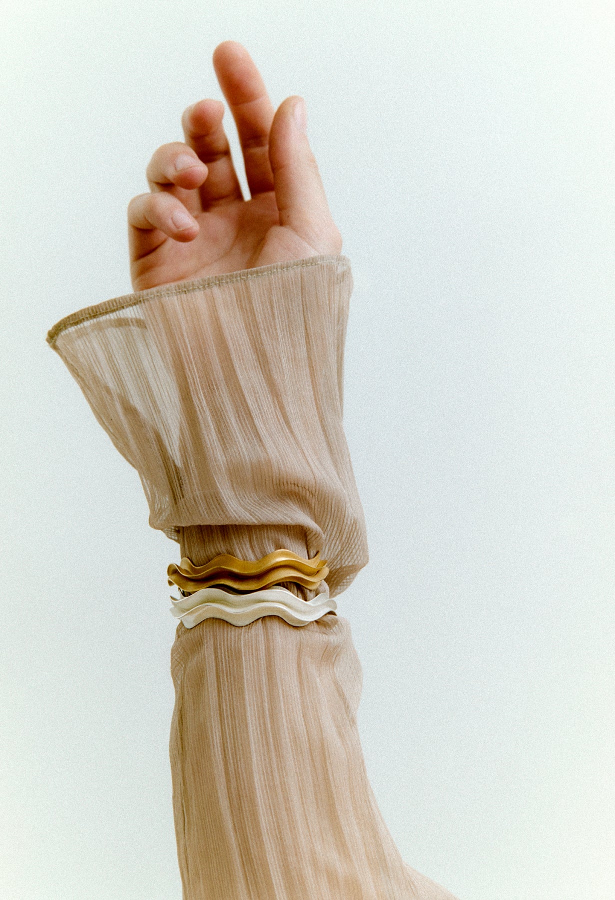 Close-up of a hand wearing bracelets with a white background