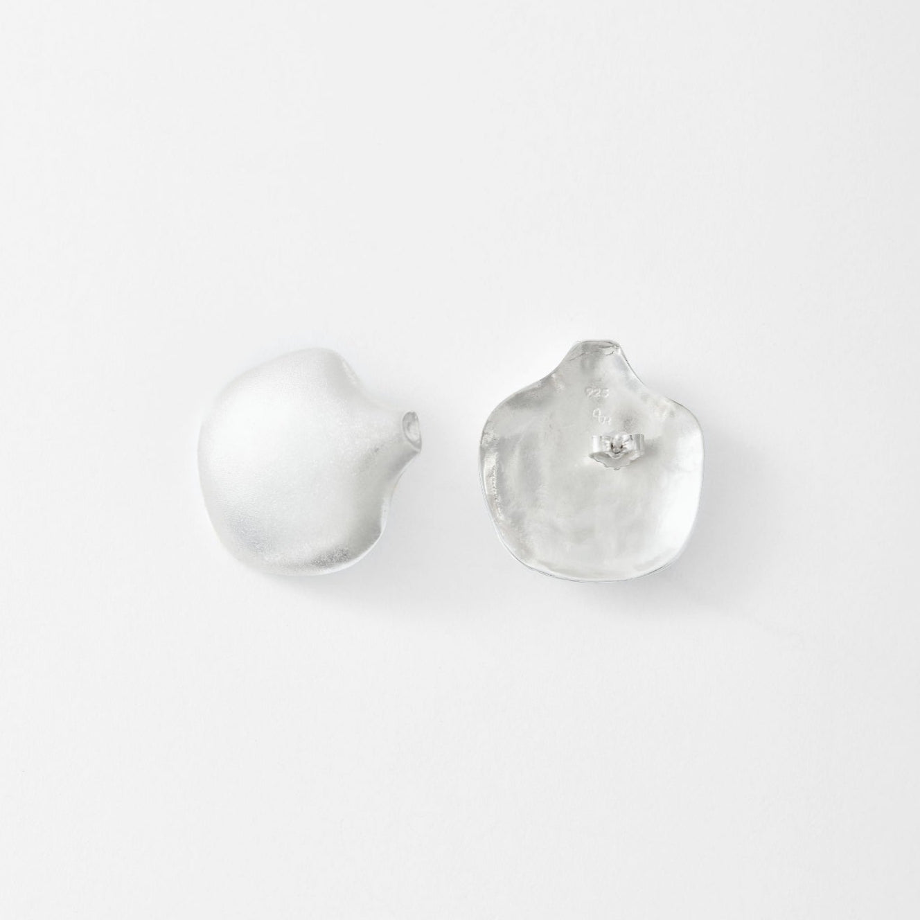 Pair of silver earrings on a light gray background