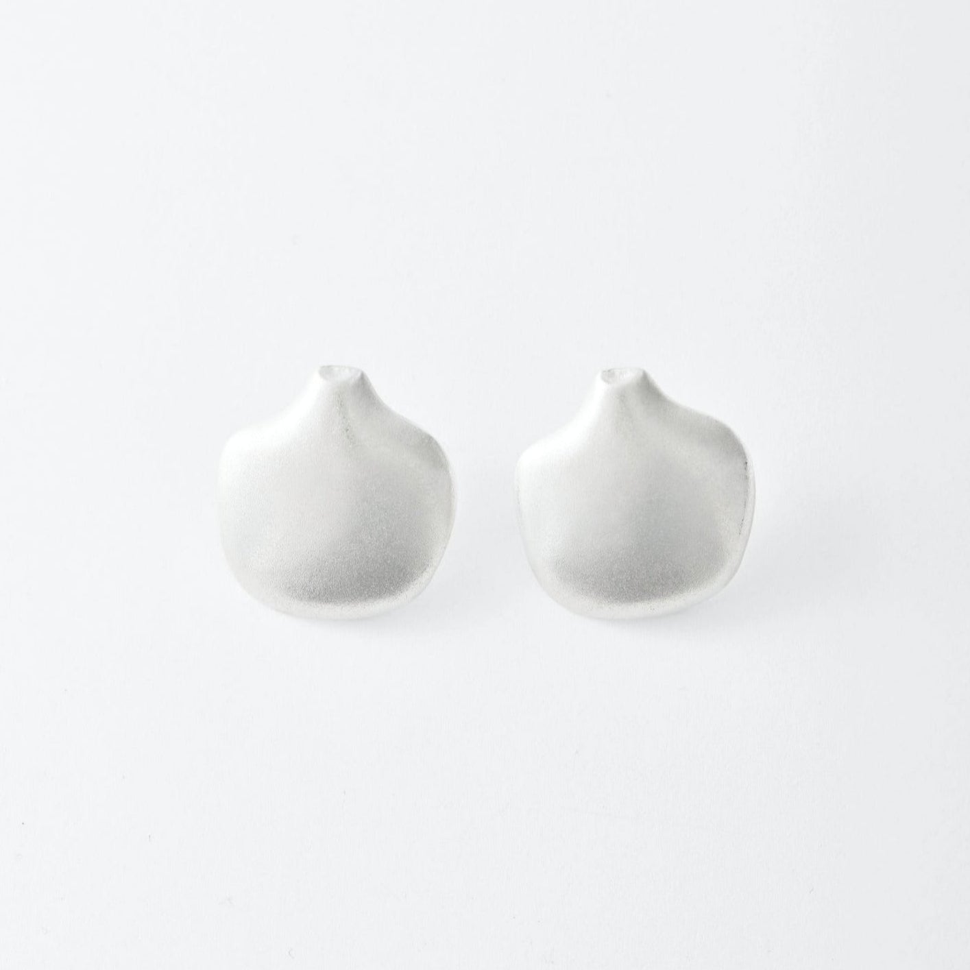 Two silver earrings on a light gray background
