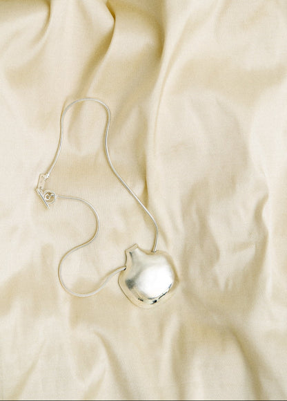 Silver necklace on a beige fabric background