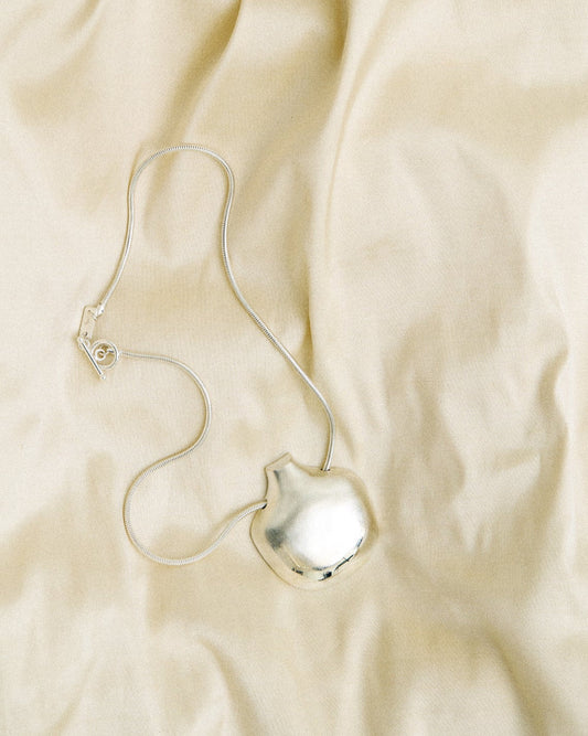 Silver necklace on a beige fabric background