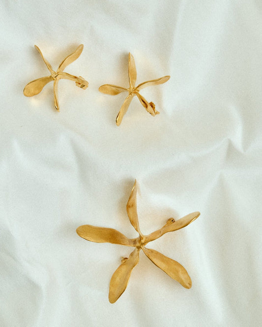 Gold jewelry on a white fabric background