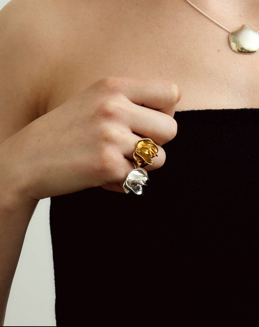 Woman wearing a black strapless top and headscarf, wearing silver and gold jewelry