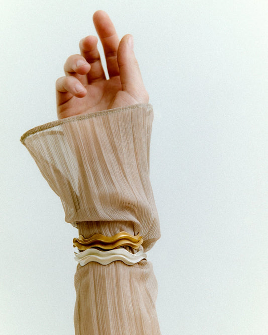 Close-up of a hand wearing bracelets with a white background
