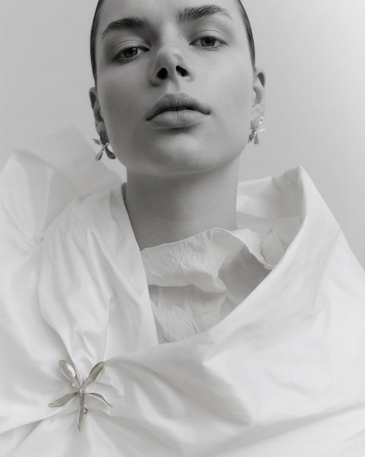 Woman wearing gold jewelry against a plain background