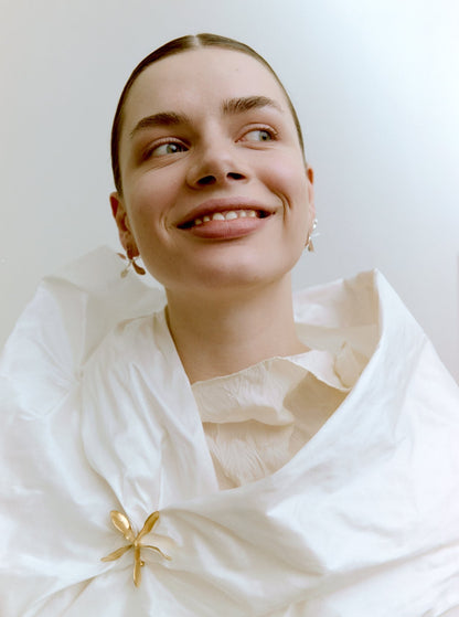 Woman wearing gold jewelry against a light background
