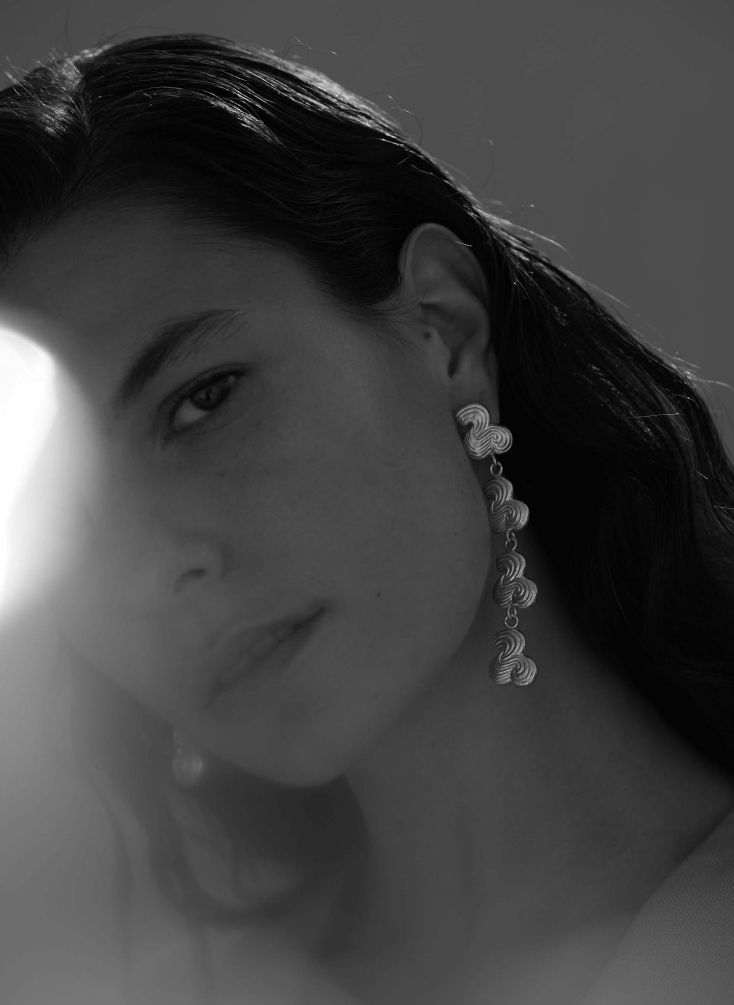 Female model wearing drop earring in silver
