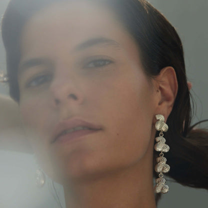 Female model wearing drop earring in silver