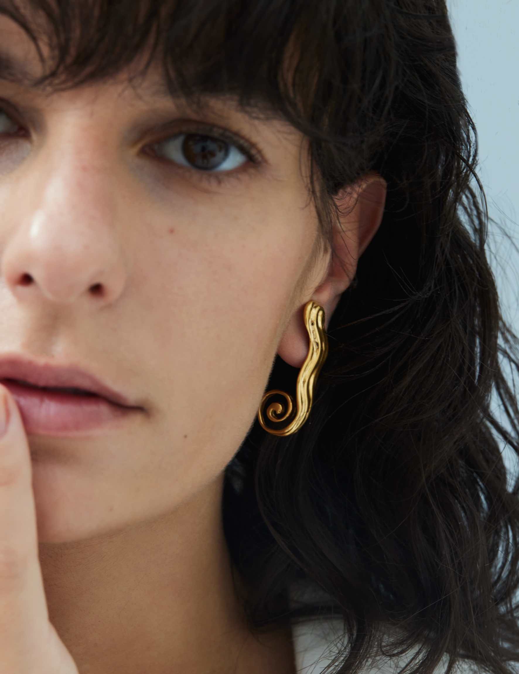 Close-up of model wearing gold earring
