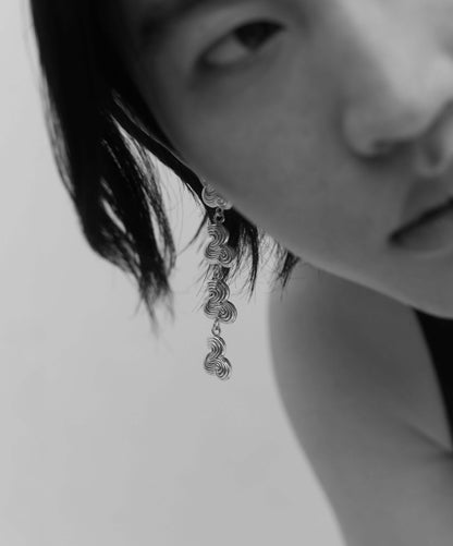 Male model wearing drop earring in silver