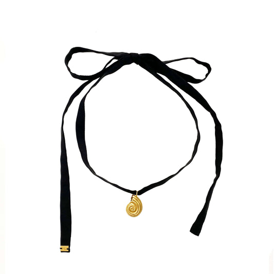 Small gold pendant with black silk ribbon