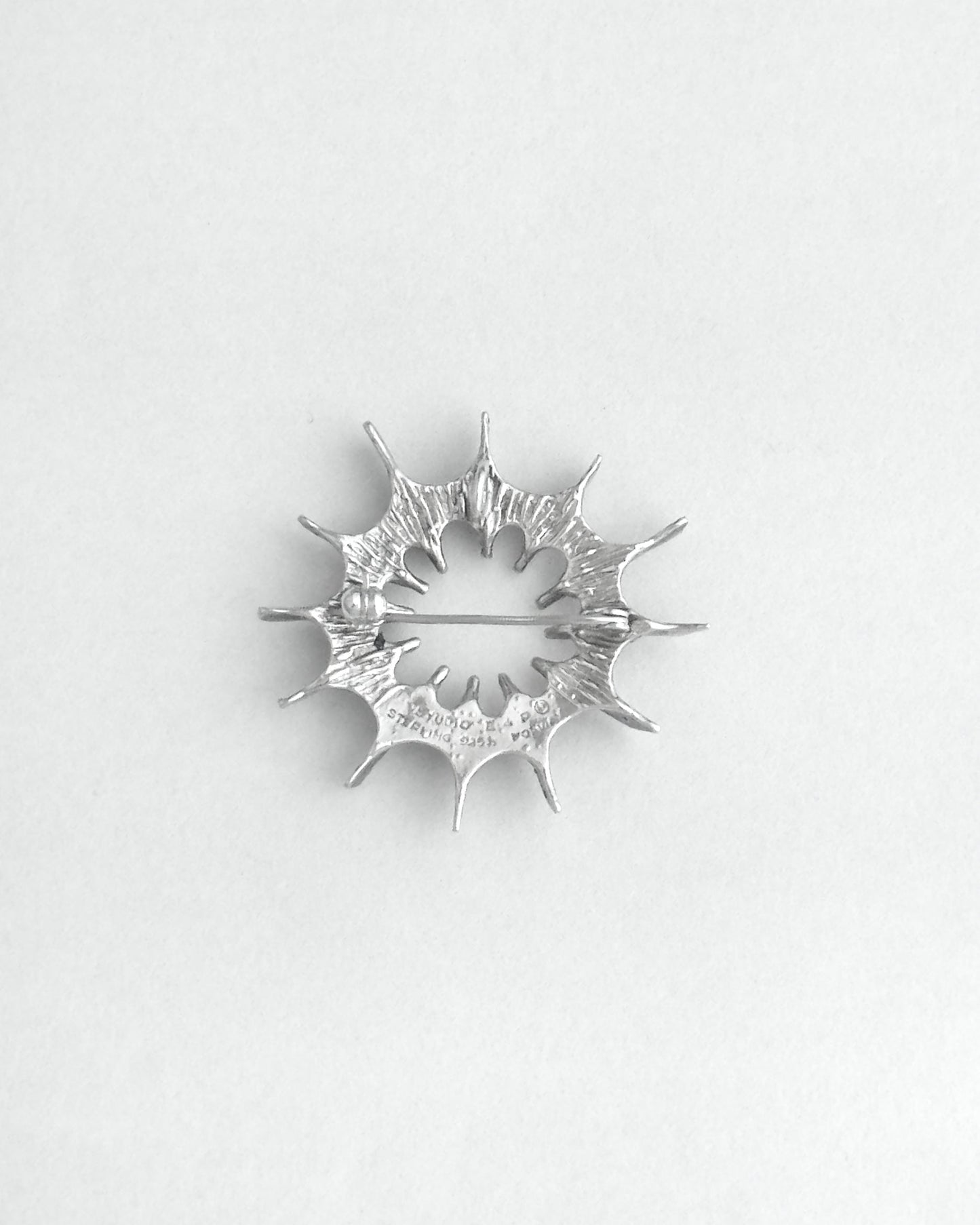 Silver star-shaped brooch on a white background