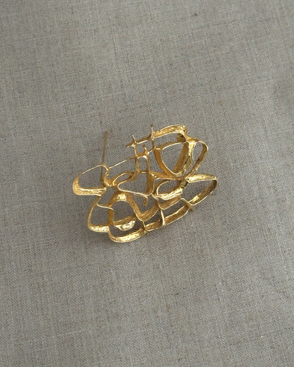Gold brooch on a textured gray background