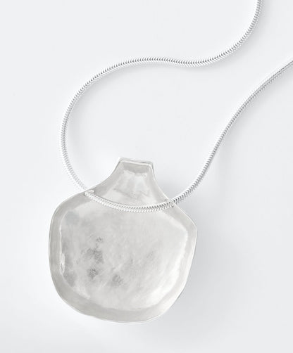Necklace with a large, textured pendant on a white background
