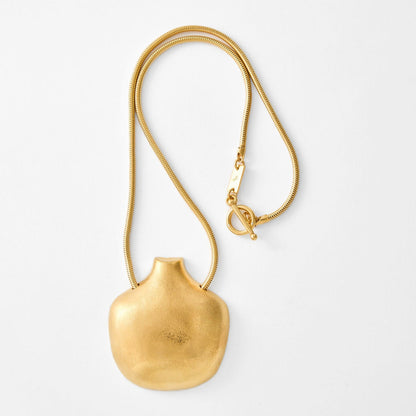 Gold necklace with a pendant on a white background
