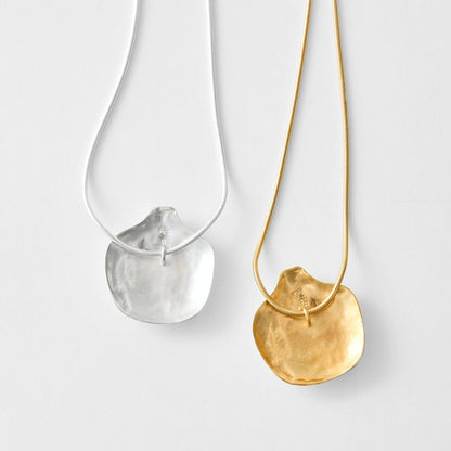 Gold necklace and silver necklace on a light gray background