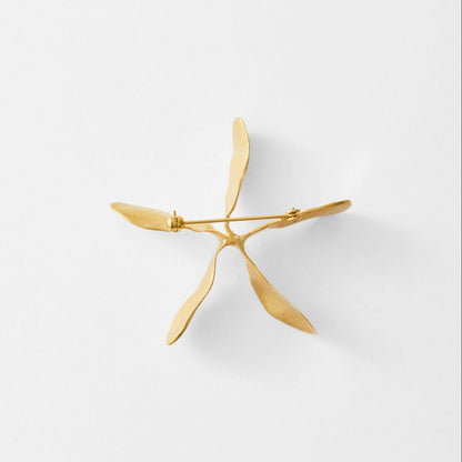 Gold earring on a light gray background