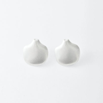 Two silver earrings on a light gray background