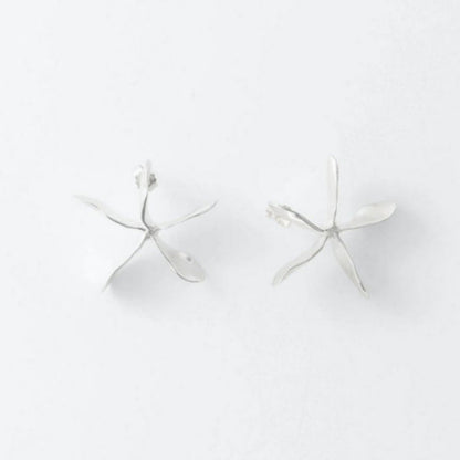 Two silver earrings on a light gray background