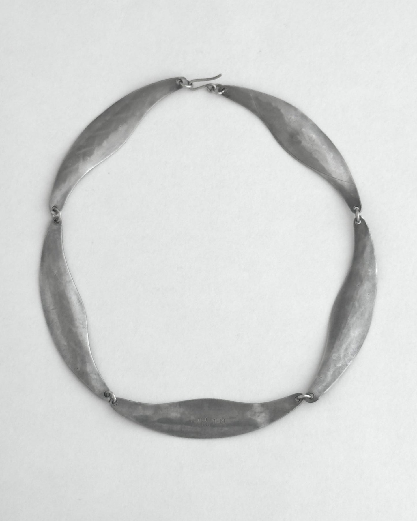 Pewter necklace on a light gray background