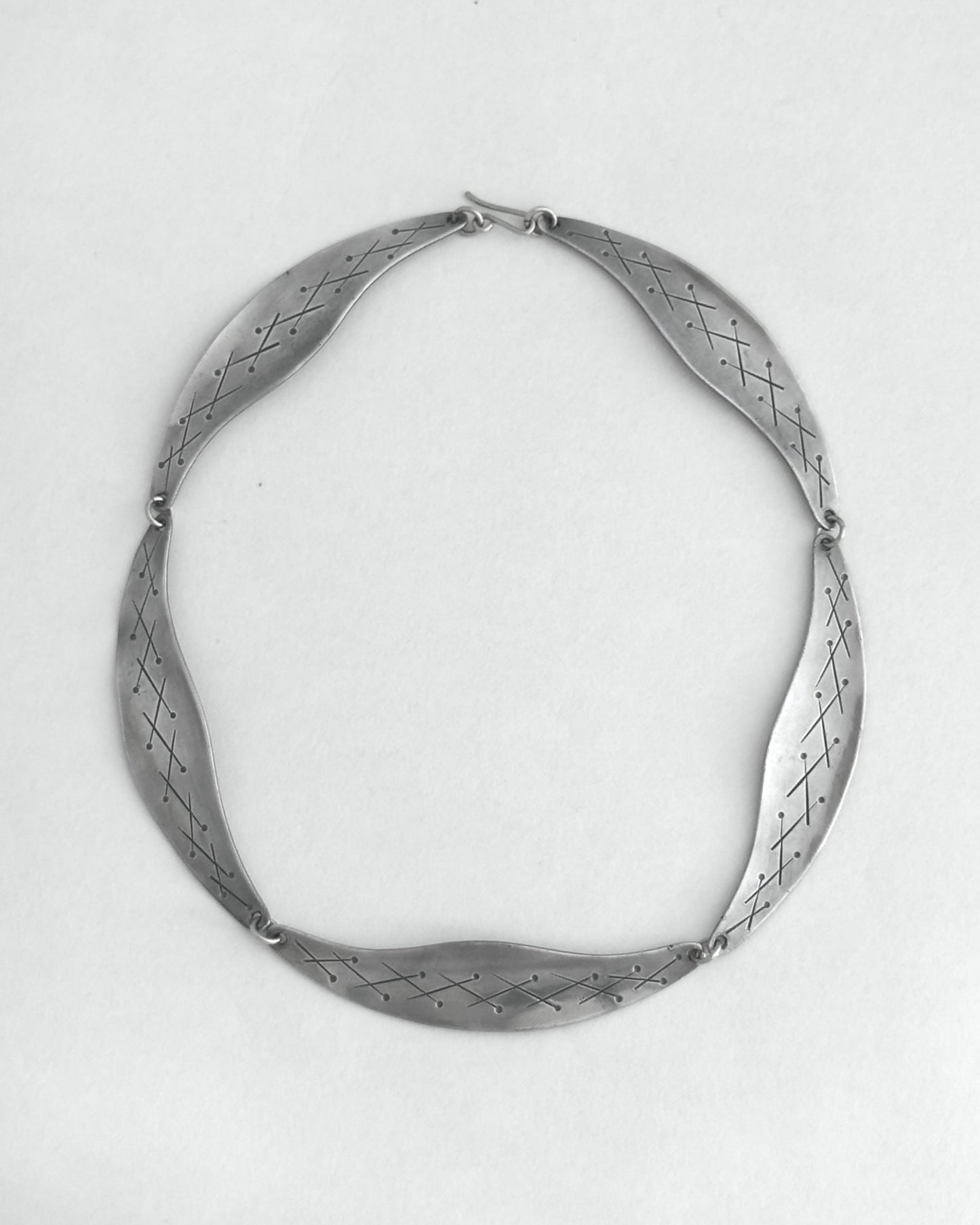 Pewter necklace on a light gray background