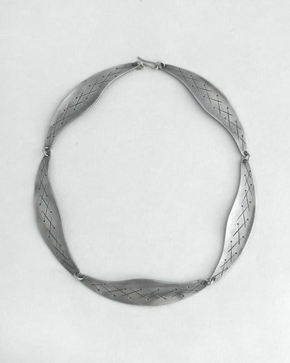 Pewter necklace on a light gray background