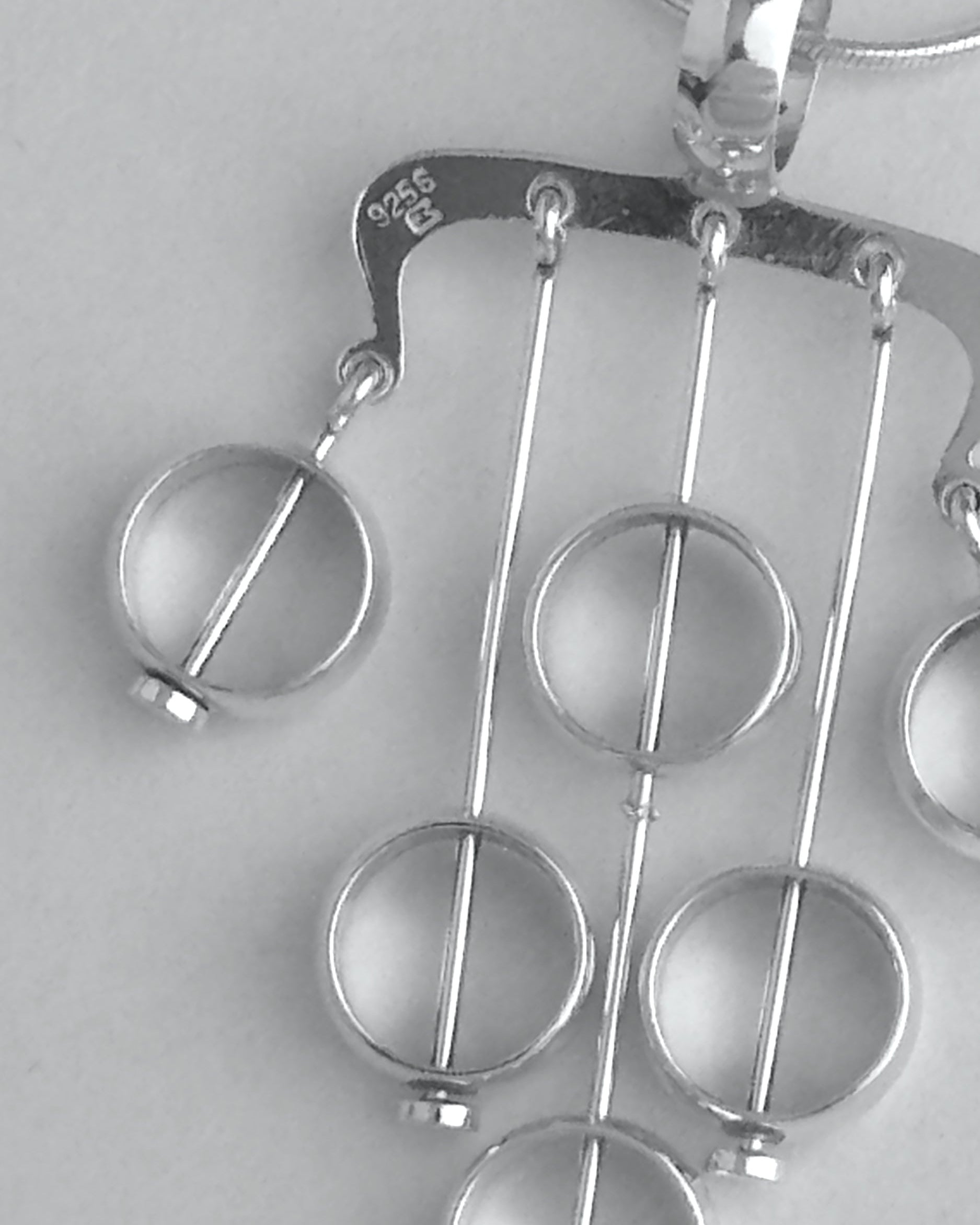 Silver necklace with a unique pendant on a light gray background