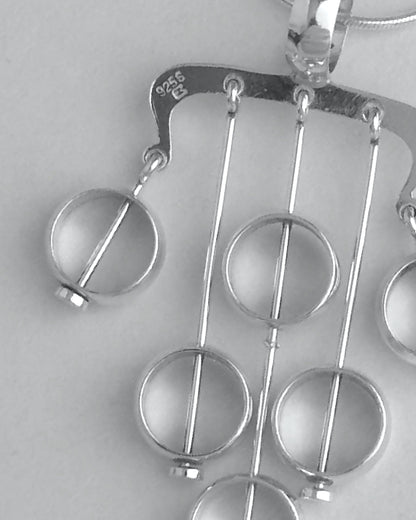 Silver necklace with a unique pendant on a light gray background