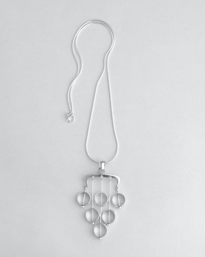 Silver necklace with a unique pendant on a light gray background