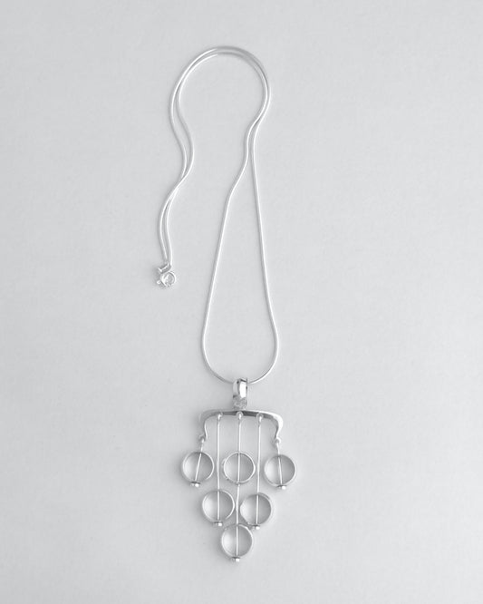 Silver necklace with a unique pendant on a light gray background