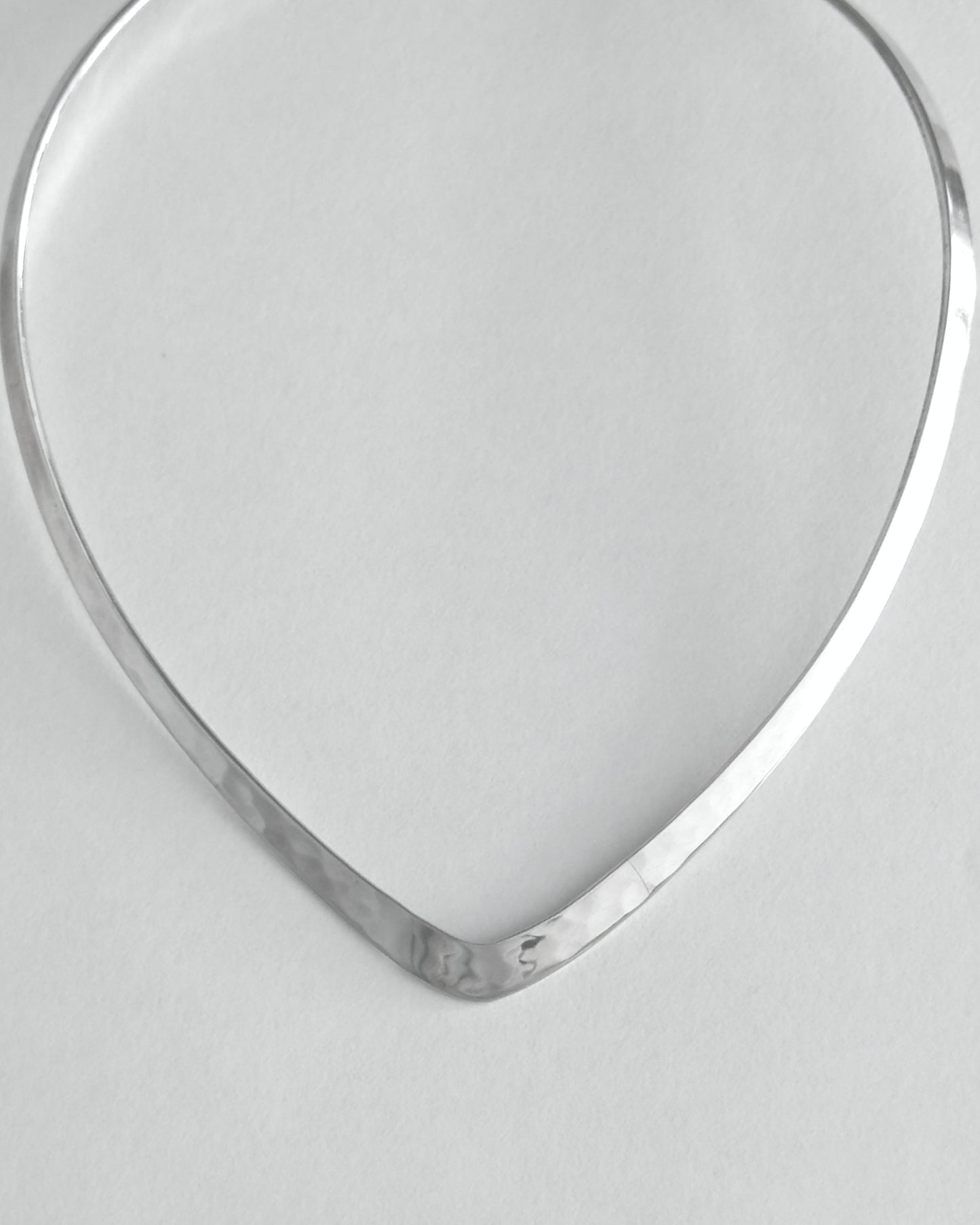 Silver necklace on a light gray background