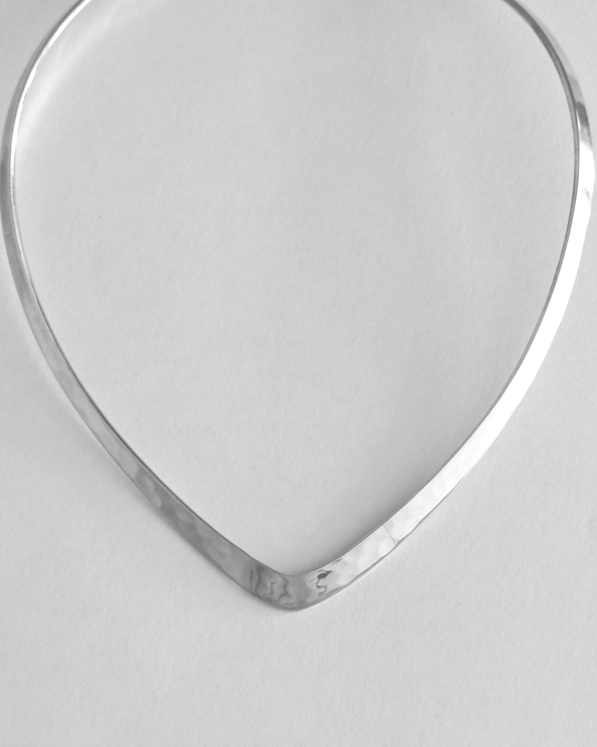 Silver necklace on a light gray background