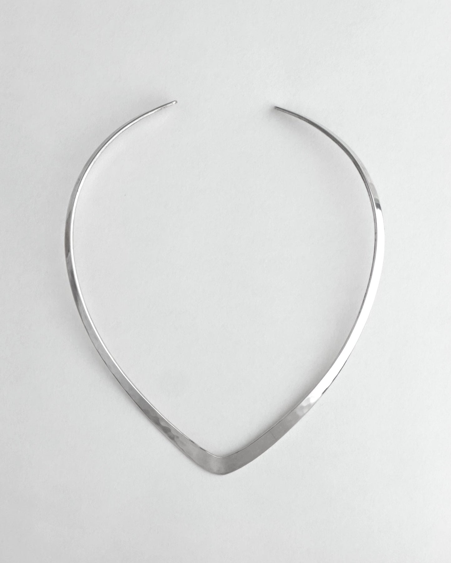 Silver necklace on a light gray background