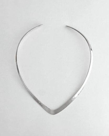 Silver necklace on a light gray background