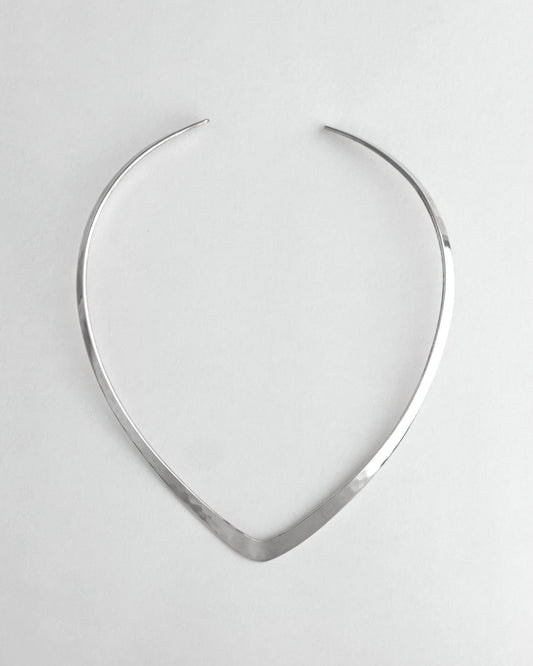 Silver necklace on a light gray background