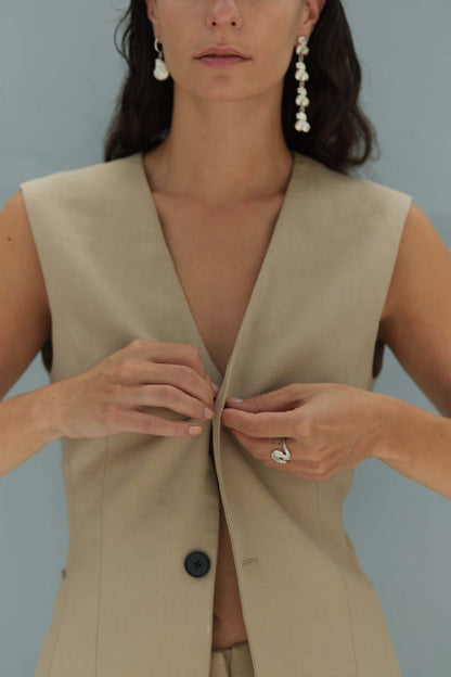 Female model wearing silver jewelry and a vest