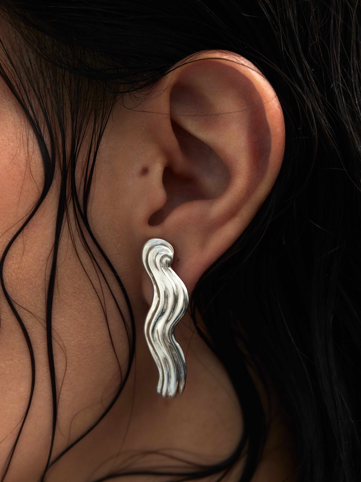 Models ear wearing a silver earring