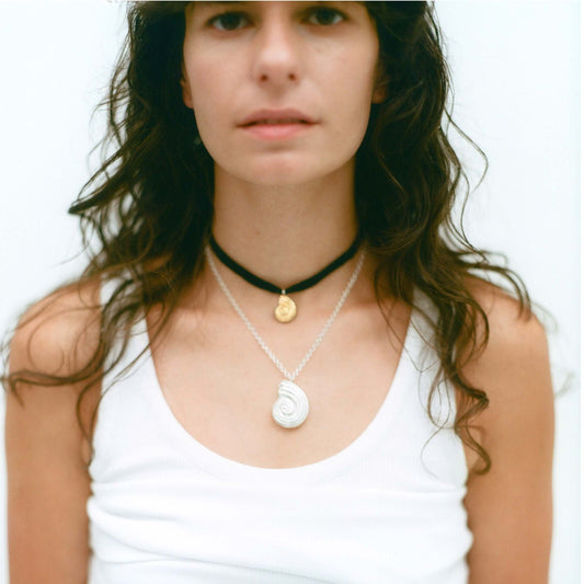 Female model wearing gold and silver necklaces