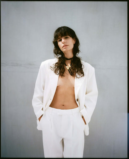 Female model with white suit, wearing gold necklace