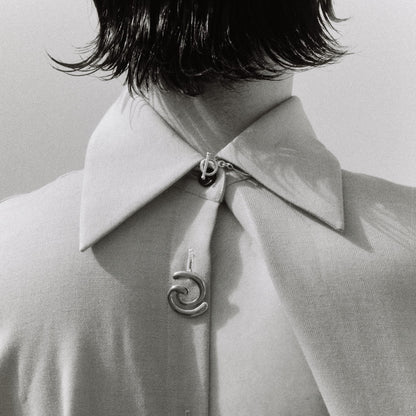 Models back wearing a shirt decorated with silver jewelry