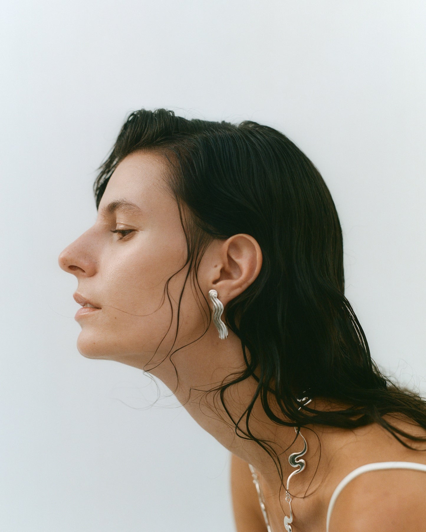 Female model in profile, wearing silver jewelry