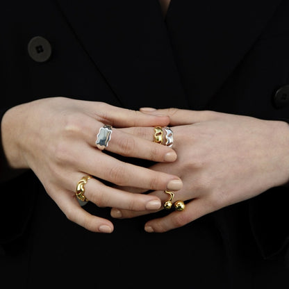Female hands held together, wearings many rings
