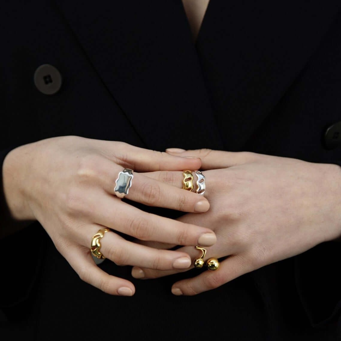 Female hands held together, wearings many rings