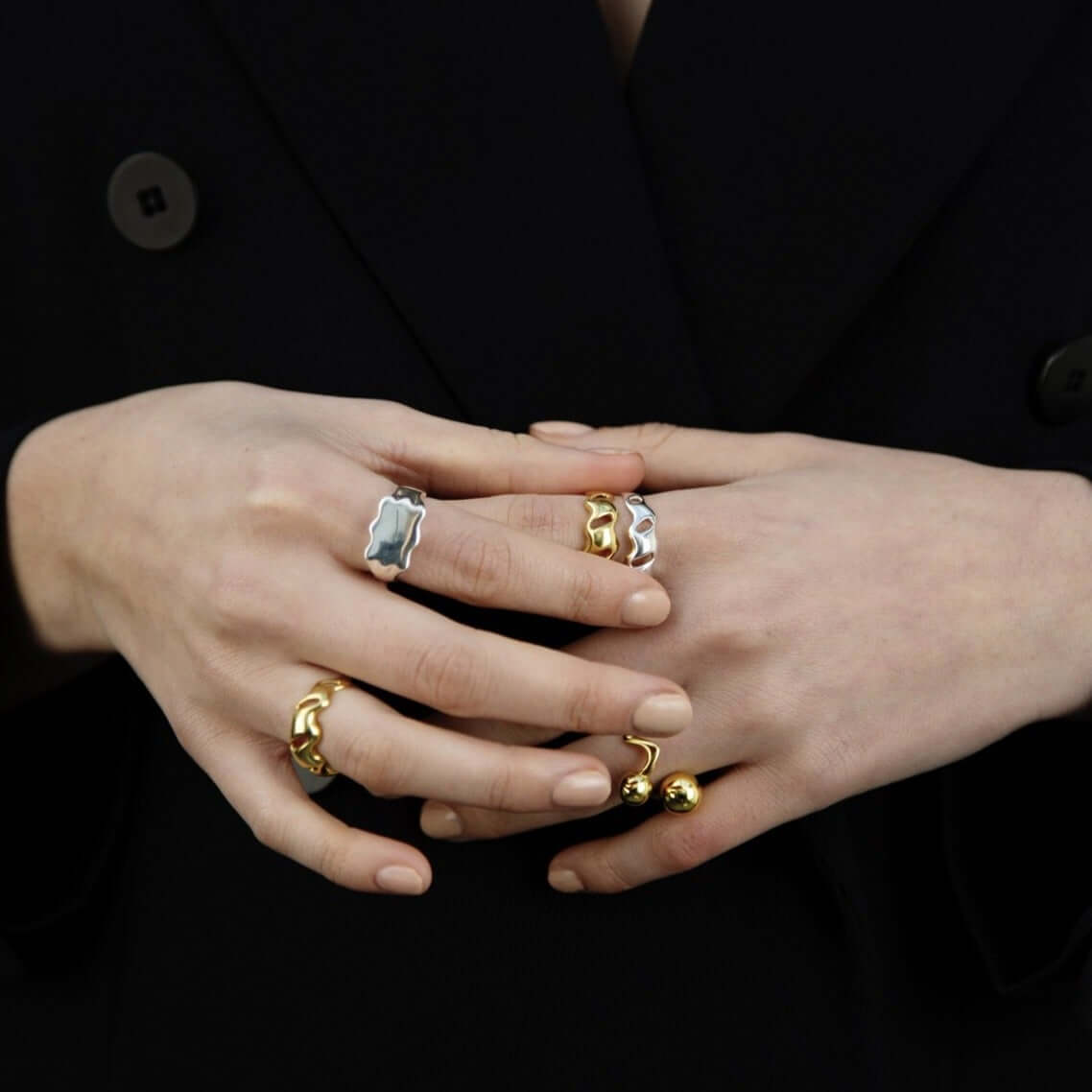 Female hands held together, wearings many rings