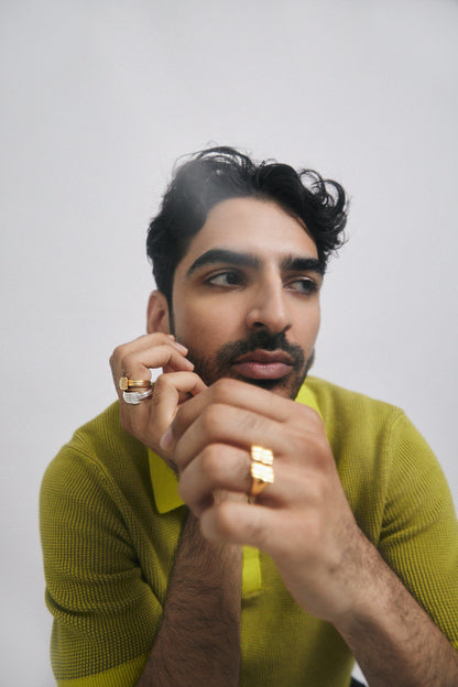 Man in green shirt wearing many rings