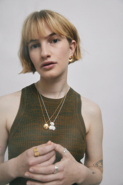 Woman in green top, wearing jewelry