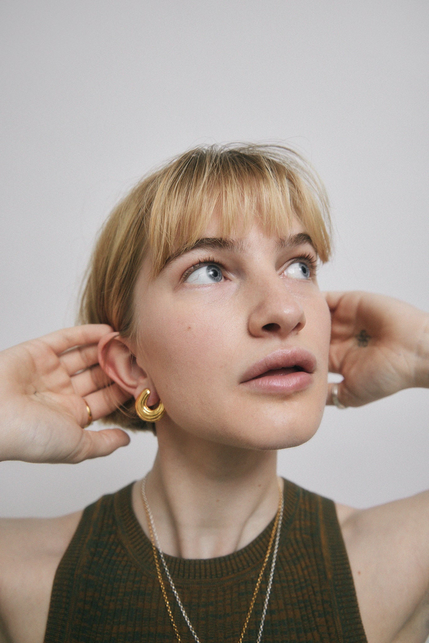 Model wearing gold earrings