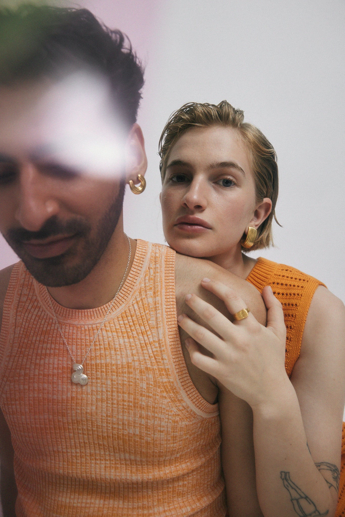 Man and woman in orange clothes, wearing jewelry