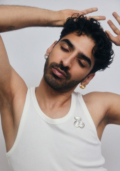 Man with closed eyes, wearing a silver brooche