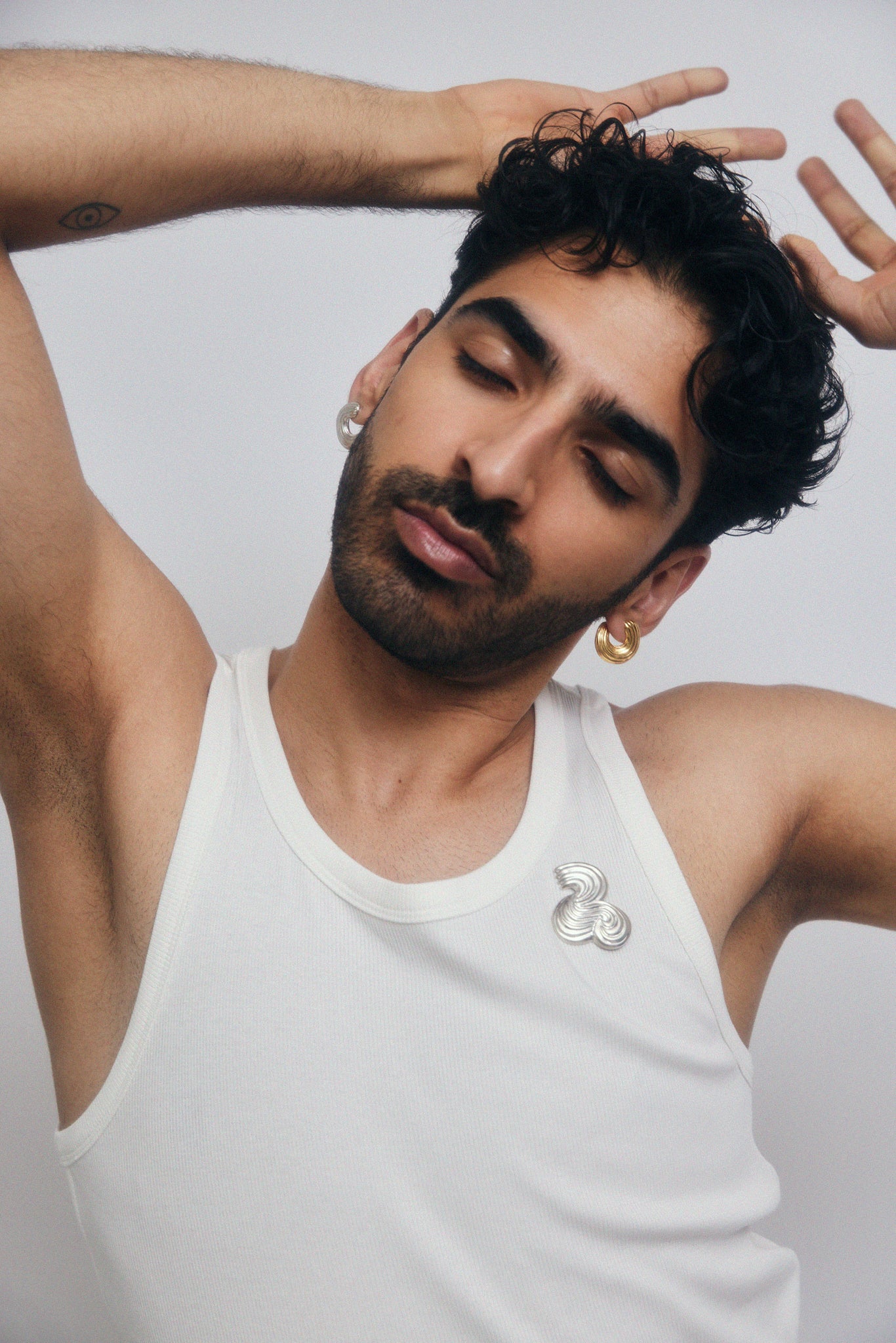Male model wearing jewelry, with closed eyes